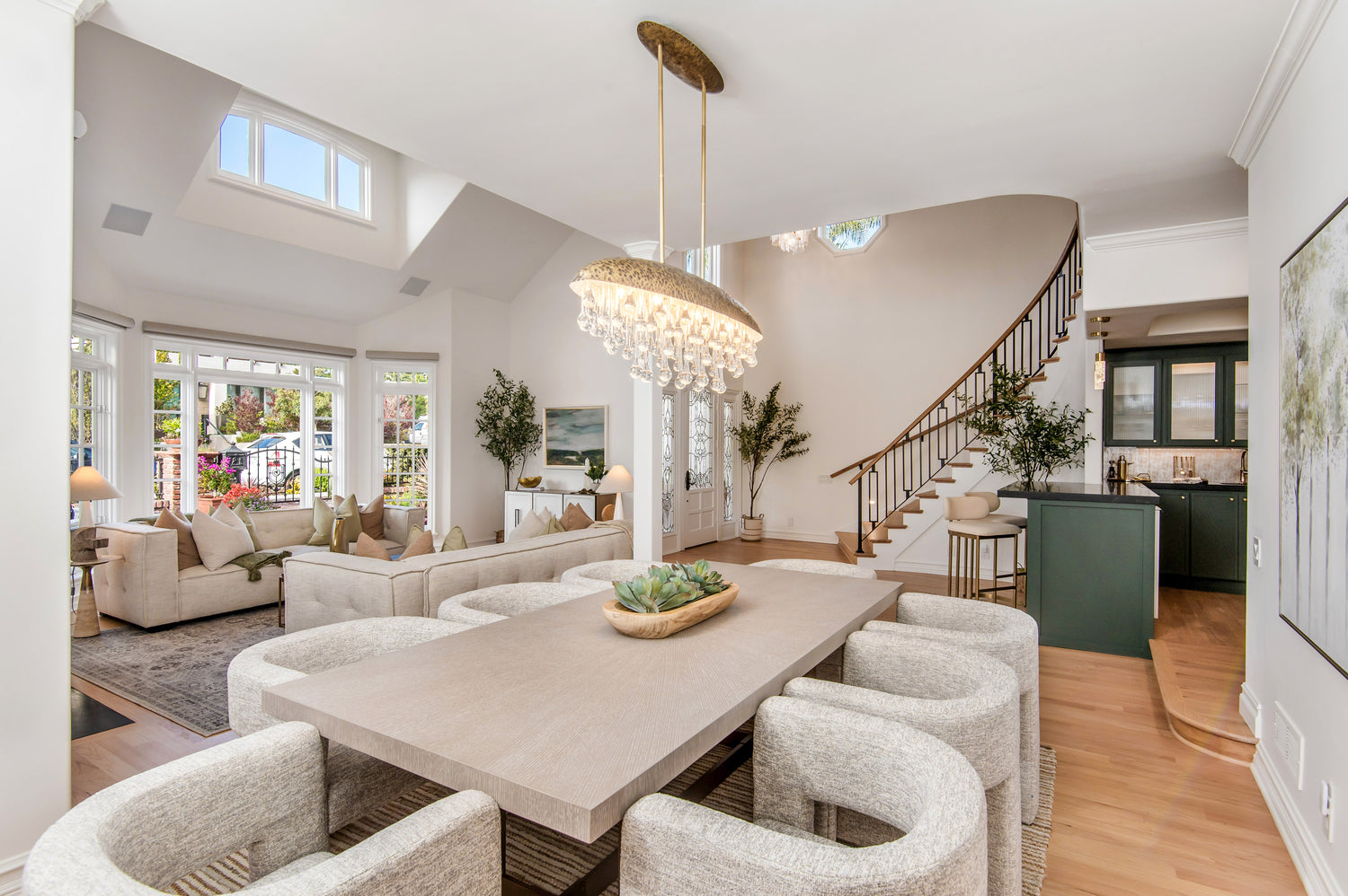 Modern living room with a dining table and chairs, staircase, and large windows.
Details