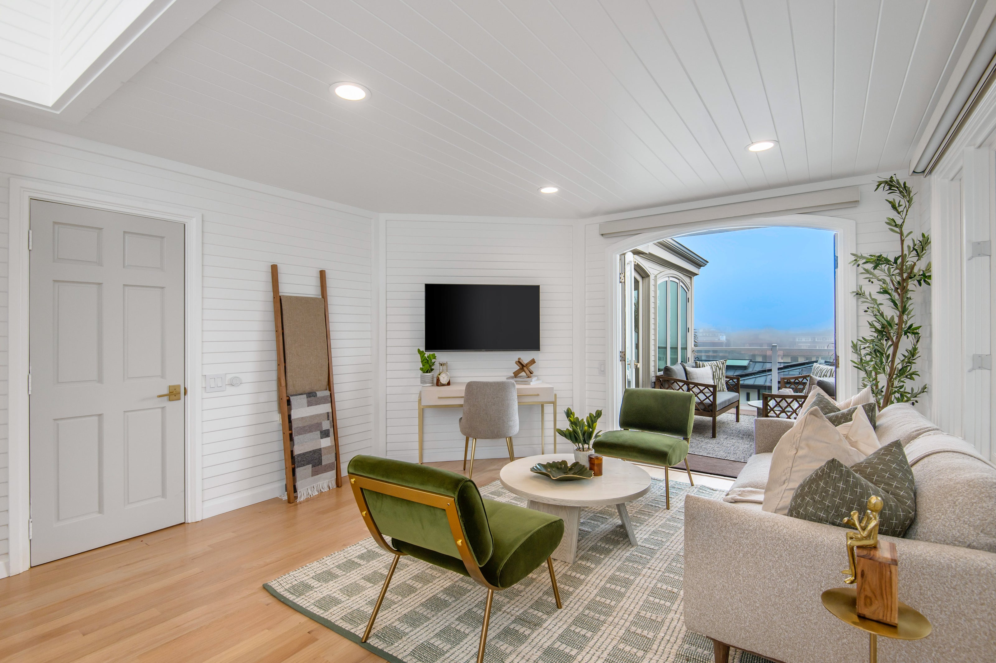 Modern living room with green chairs, a beige sofa, and a television.