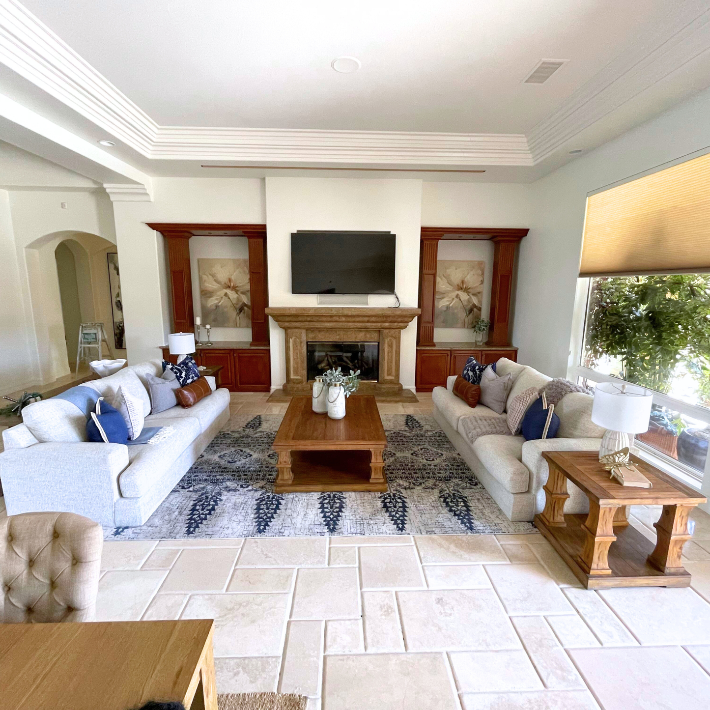 Living room with white sofas, wooden coffee table, and fireplace.