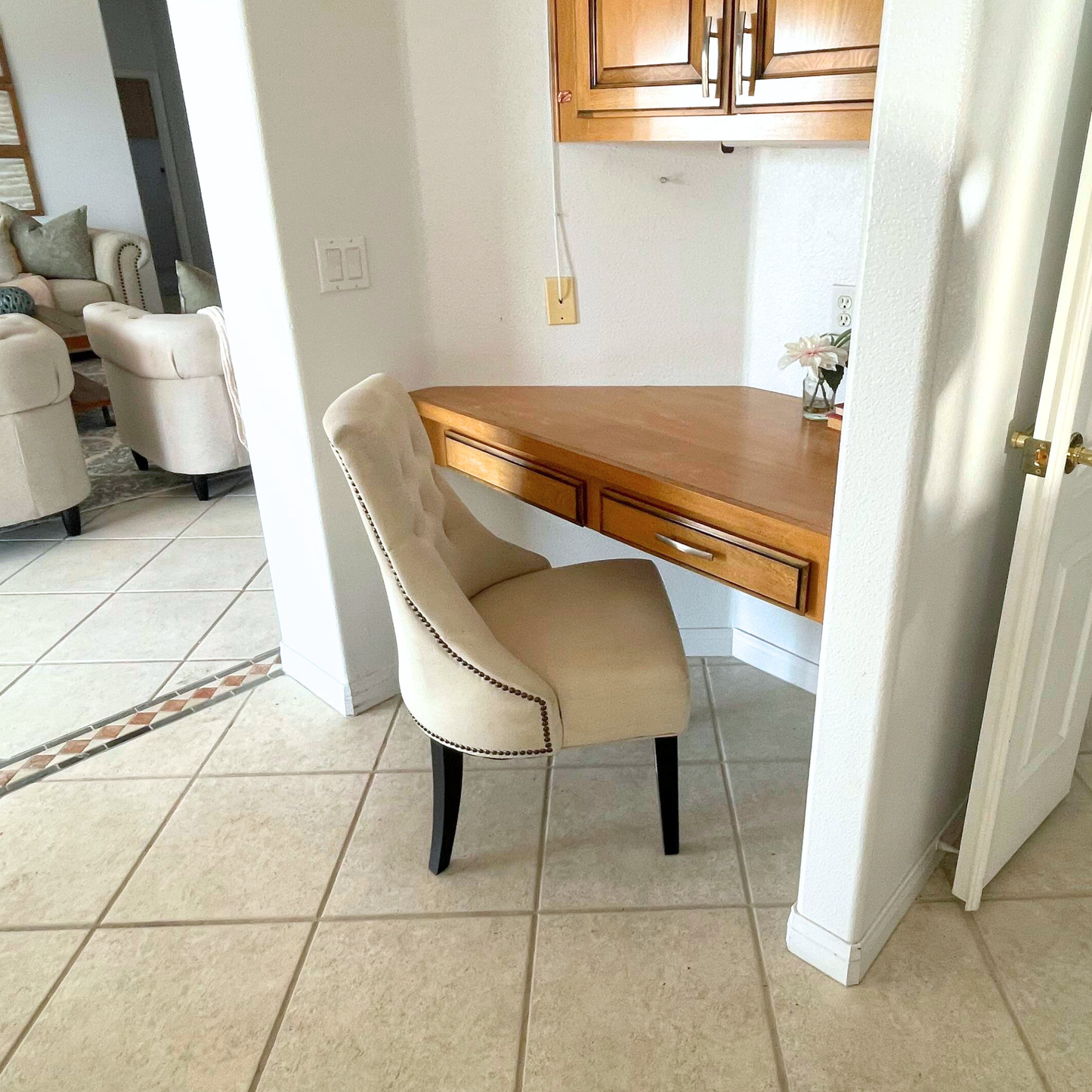 Beige chair in front of a wooden desk in a home office setting.
