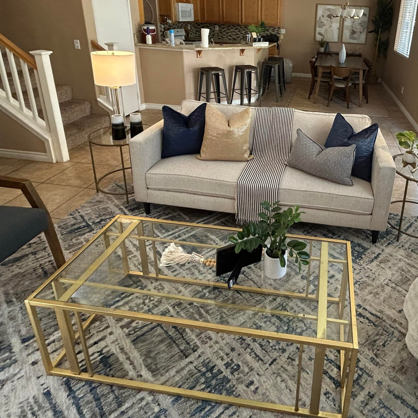 Brass & glass coffee table in a staged living room. 
