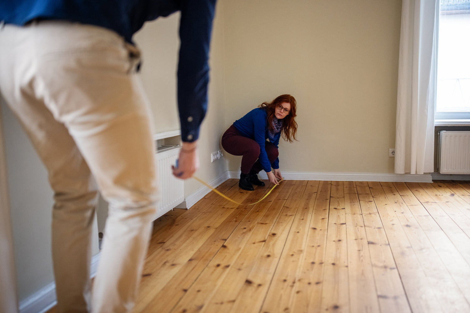 Preview the property - image of people taking measurements of a room