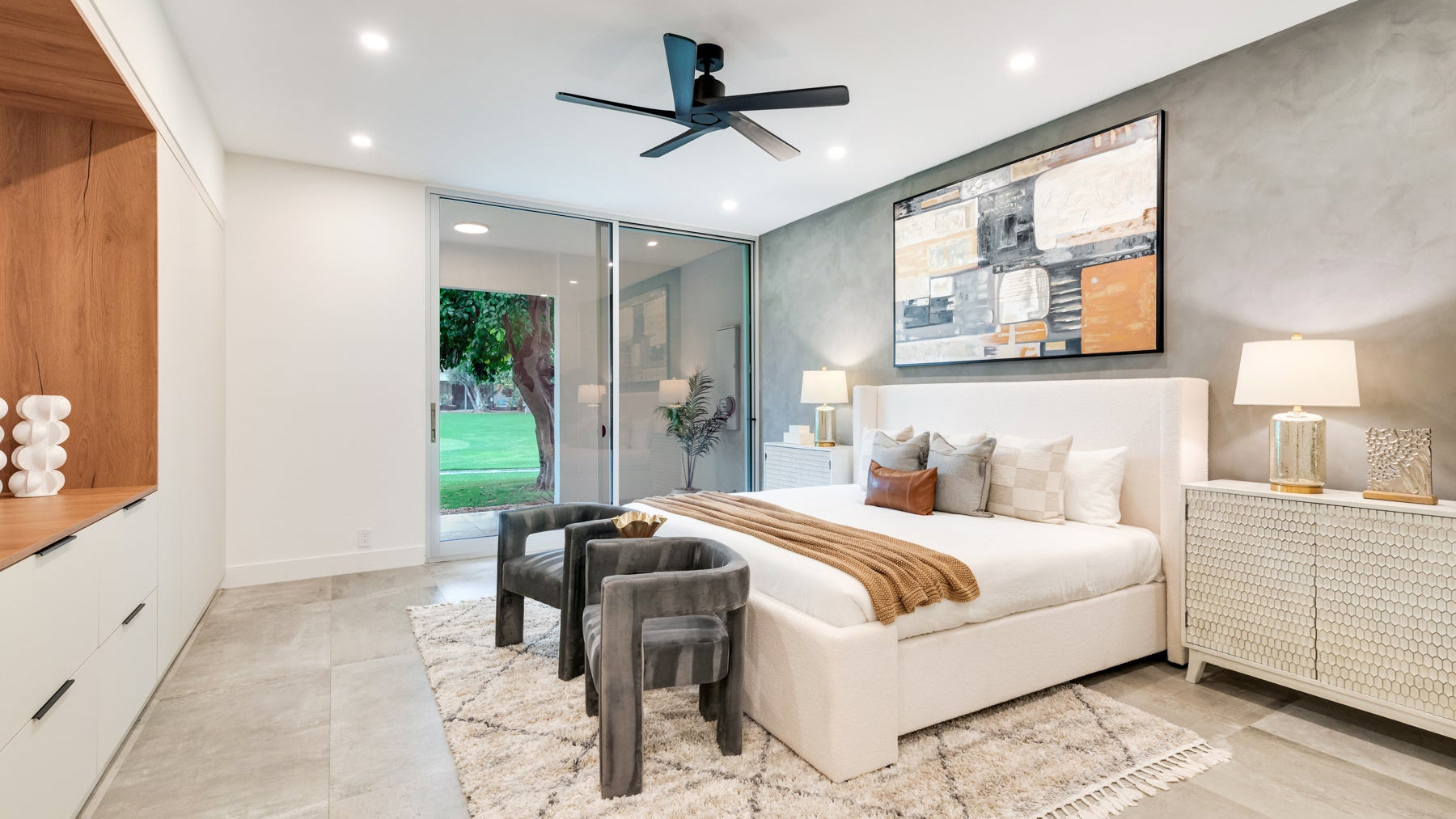 Modern bedroom - cream bed, gray chairs, art
