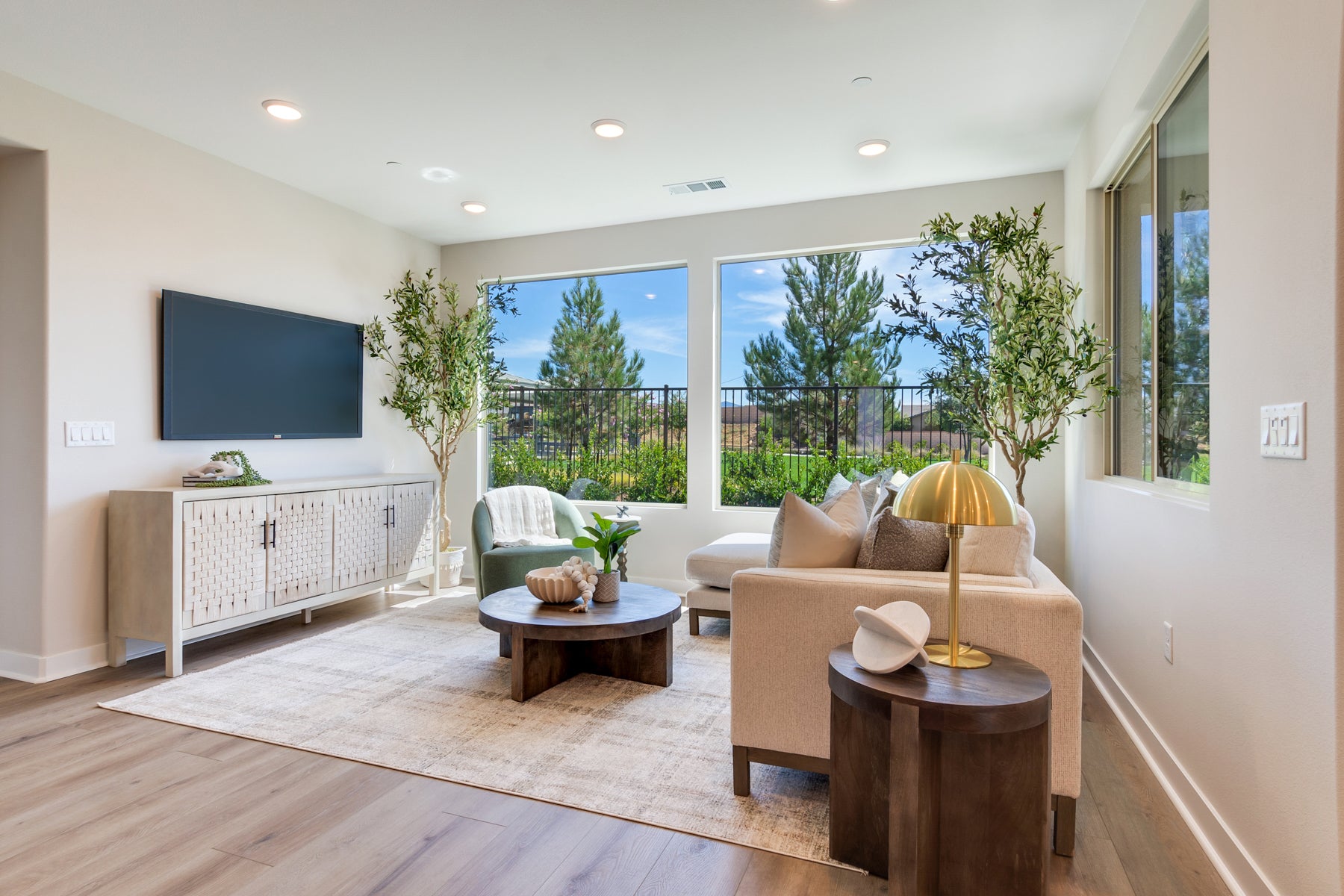 Modern living room with a TV, sofa, and coffee table in a well-lit room.