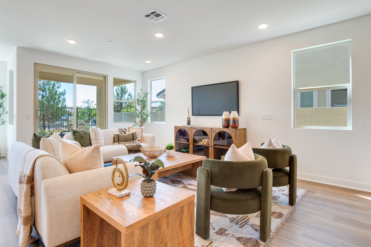 Modern living room with beige sofa, green armchair, and wooden coffee table.