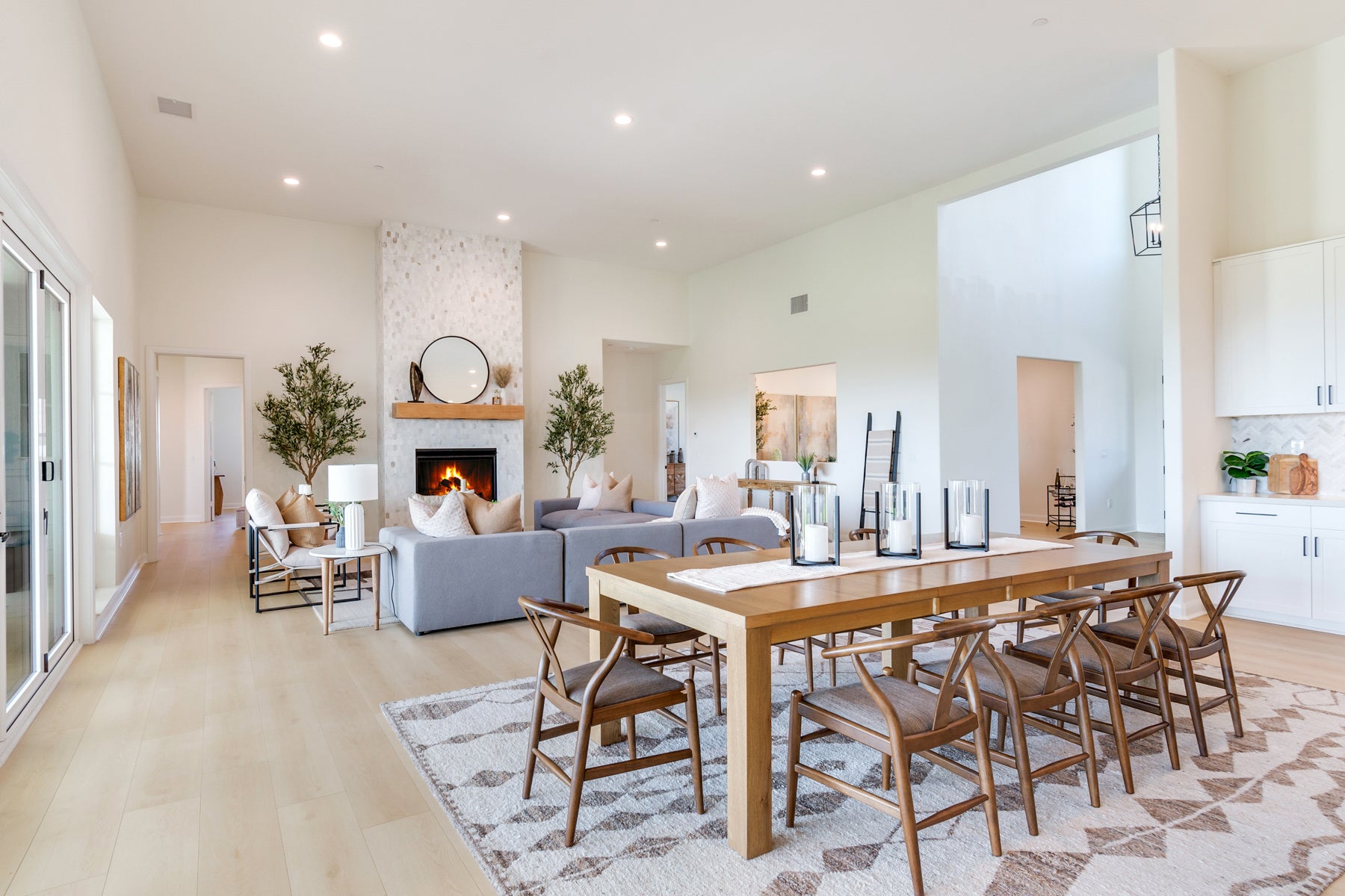 Modern living room with a fireplace, dining table, and chairs.