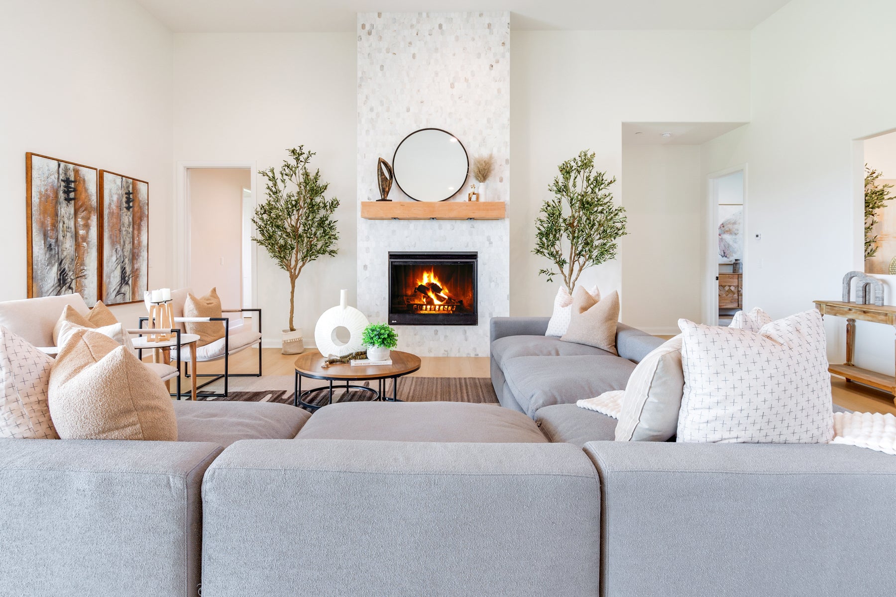 Modern living room with gray sofa, fireplace, and decorative elements.